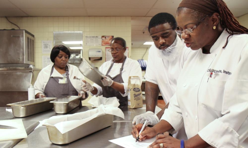 image of chefs in white coats cooking in kitchen